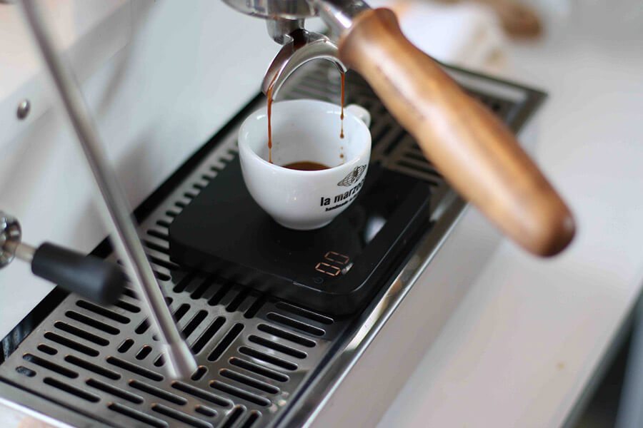 Espresso pouring into a cup on an Acaia Lunar scale